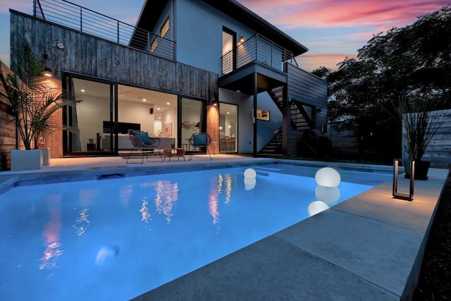 outdoor pool featuring stairs and a patio area