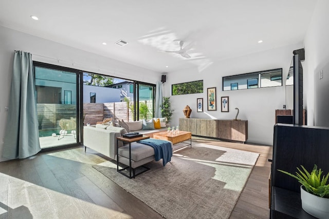 living area with wood finished floors, ceiling fan, and recessed lighting