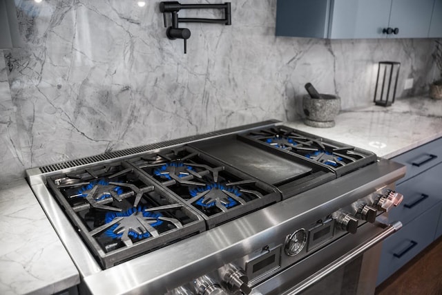2800 Del Curto Rd Unit 9, Austin, TX 78704 - kitchen view of high end stainless steel range, decorative backsplash, pot filler, and light stone counters
