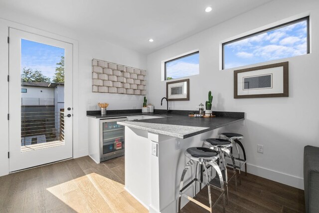 2800 Del Curto Rd Unit 9, Austin, TX 78704 - kitchen featuring wine cooler, a kitchen breakfast bar, dark wood finished floors, a peninsula, and recessed lighting