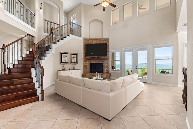 8293 Lime Creek Rd, Volente, TX 78641 - living area featuring a towering ceiling, a ceiling fan, french doors, stairway, and tile patterned flooring