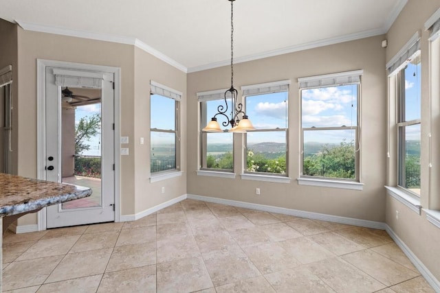 unfurnished dining area with healthy amount of natural light, crown molding, a chandelier, and baseboards
