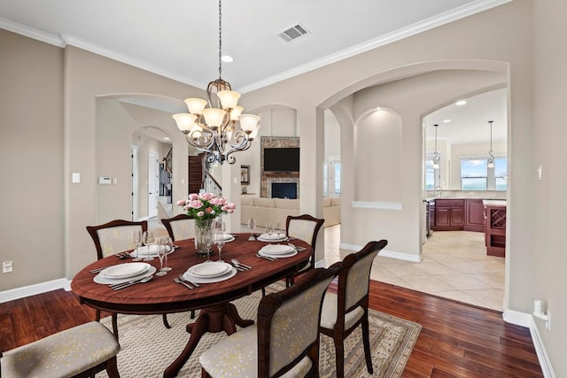 8293 Lime Creek Rd, Volente, TX 78641 - dining space with arched walkways, light wood-style flooring, ornamental molding, a chandelier, and baseboards
