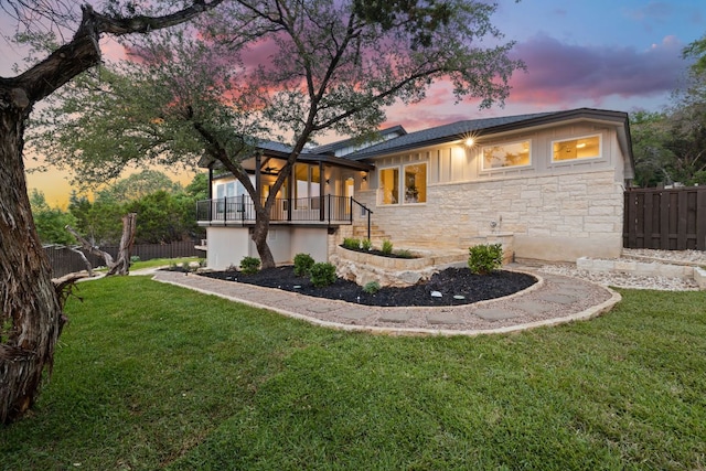 back of property at dusk with stone siding