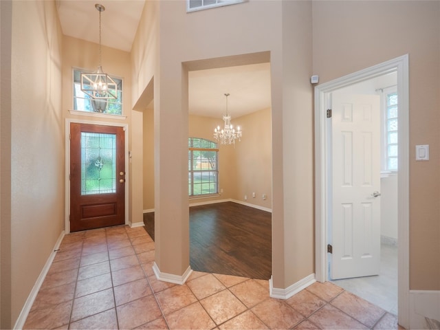 11029 Ballybunion Pl, Austin, TX 78747 - entrance foyer with a chandelier, a towering ceiling, baseboards, and light tile patterned flooring