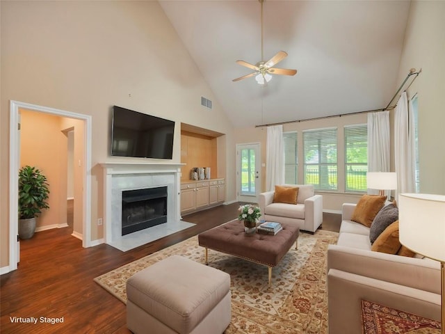 11029 Ballybunion Pl, Austin, TX 78747 - living room with high vaulted ceiling, ceiling fan, dark wood-style floors, baseboards, and a premium fireplace