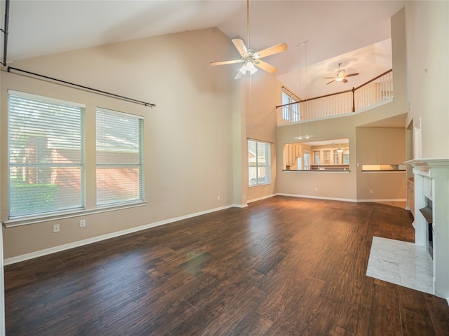 11029 Ballybunion Pl, Austin, TX 78747 - unfurnished living room with high vaulted ceiling, ceiling fan, a fireplace with flush hearth, wood finished floors, and baseboards
