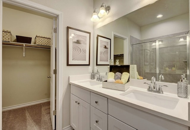 532 Emory Crossing Blvd, Hutto, TX 78634 - full bathroom with double vanity, a spacious closet, a shower stall, and baseboards