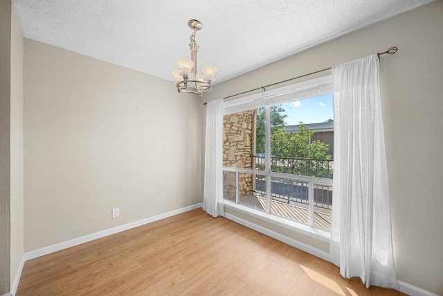 500 Riverside Dr E Unit 255, Austin, TX 78704 - spare room with a chandelier, wood finished floors, and a textured ceiling