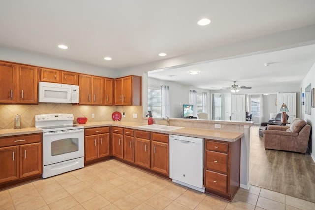 210 Salt Creek Ln, Georgetown, TX 78633 - kitchen with white appliances, a sink, a peninsula, brown cabinetry, and light countertops