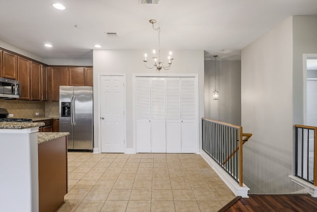 14815 Avery Ranch Blvd Unit 3401, Austin, TX 78717 - kitchen featuring appliances with stainless steel finishes, a chandelier, tasteful backsplash, decorative light fixtures, and light stone counters