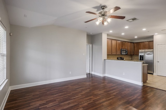 14815 Avery Ranch Blvd Unit 3401, Austin, TX 78717 - kitchen featuring appliances with stainless steel finishes, a ceiling fan, wood finished floors, light stone counters, and backsplash