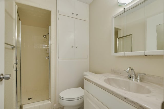 bathroom with a shower stall, toilet, and vanity