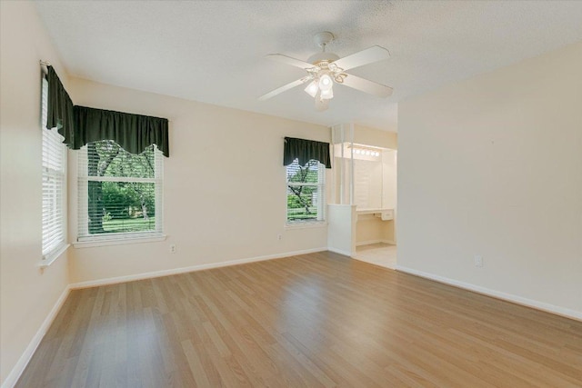 empty room with light wood-style floors, baseboards, and ceiling fan