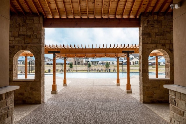 view of patio / terrace featuring a community pool and a pergola