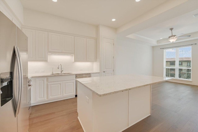 102 Bella Toscana Ave Unit 1306, Lakeway, TX 78734 - kitchen with stainless steel refrigerator with ice dispenser, light wood-style floors, a sink, light stone countertops, and recessed lighting
