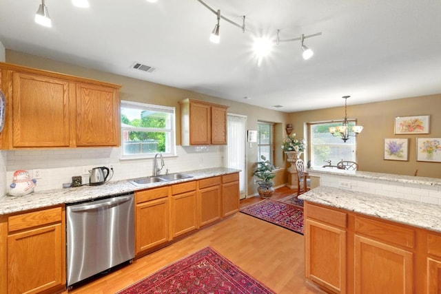 2111 Marcus Abrams Blvd, Austin, TX 78748 - kitchen featuring dishwasher, light wood finished floors, decorative backsplash, pendant lighting, and a chandelier