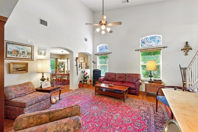 2111 Marcus Abrams Blvd, Austin, TX 78748 - living area featuring wood finished floors, arched walkways, ceiling fan, stairway, and a towering ceiling