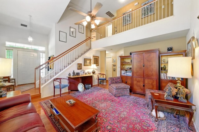 2111 Marcus Abrams Blvd, Austin, TX 78748 - living area featuring a towering ceiling, ceiling fan, wood finished floors, and stairway