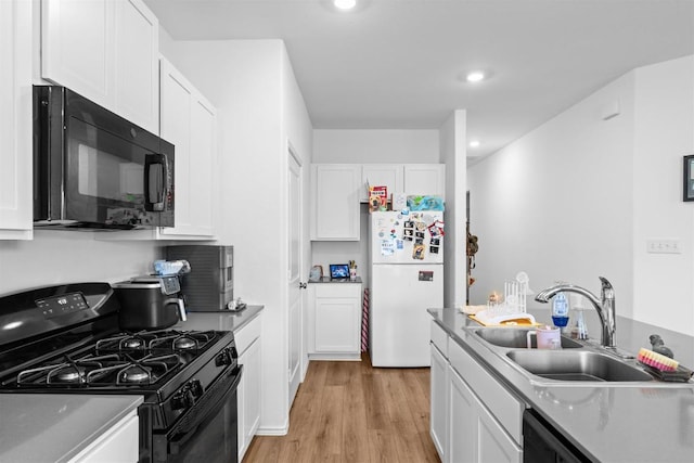 112 Montego St, Hutto, TX 78634 - kitchen with black appliances, a sink, white cabinets, light wood-style floors, and recessed lighting