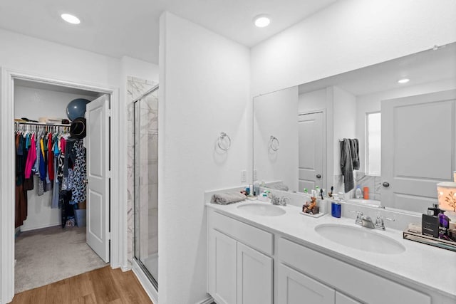 112 Montego St, Hutto, TX 78634 - full bath with a stall shower, wood finished floors, a spacious closet, double vanity, and recessed lighting