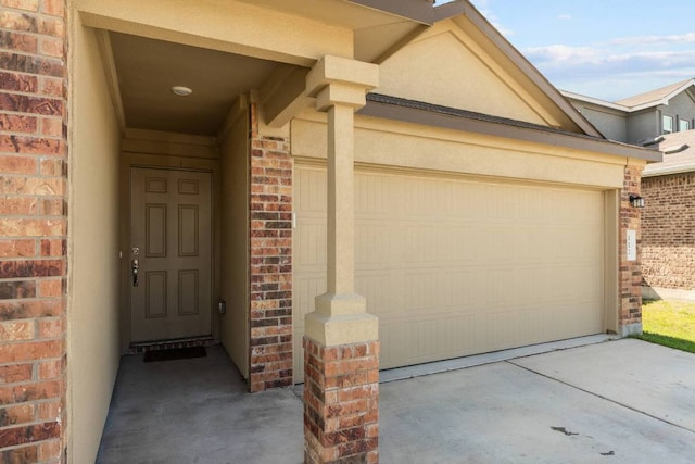 112 Montego St, Hutto, TX 78634 - entrance to property with brick siding, driveway, stucco siding, and an attached garage