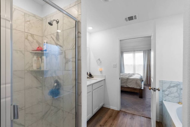 112 Montego St, Hutto, TX 78634 - full bath with wood finished floors, vanity, a stall shower, connected bathroom, and a bath