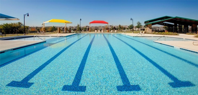 community pool featuring fence and a patio area
