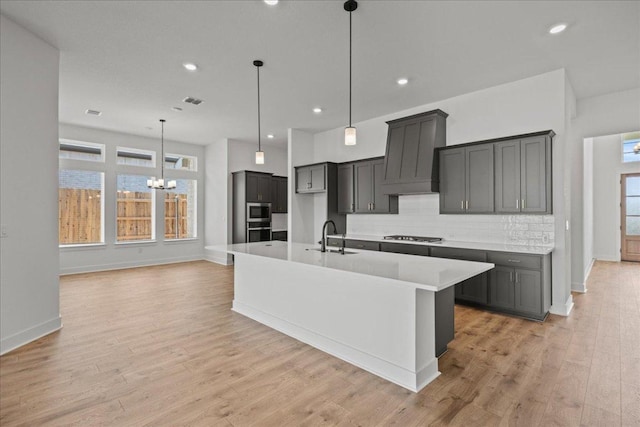 145 Lost Tree Dr, Buda, TX 78610 - kitchen featuring custom exhaust hood, appliances with stainless steel finishes, a chandelier, tasteful backsplash, and a sink