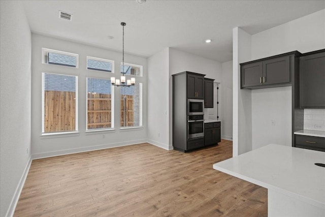 145 Lost Tree Dr, Buda, TX 78610 - kitchen with stainless steel appliances, a chandelier, light wood-type flooring, light countertops, and hanging light fixtures