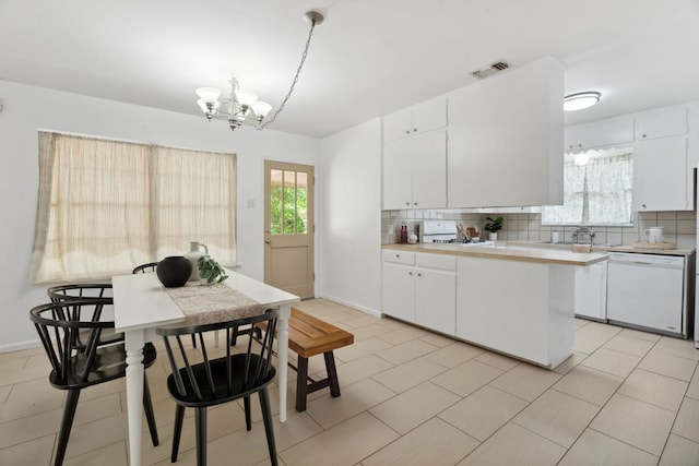 1409 Briarcliff Blvd, Austin, TX 78723 - kitchen with white dishwasher, a chandelier, backsplash, and light countertops