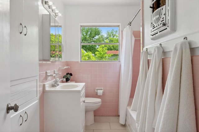 1409 Briarcliff Blvd, Austin, TX 78723 - bathroom featuring tile walls, vanity, tile patterned flooring, wainscoting, and shower / bathtub combination with curtain