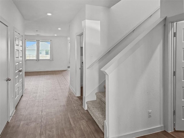 stairway featuring recessed lighting, wood finished floors, and baseboards
