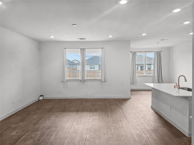 living room featuring wood finished floors, recessed lighting, and baseboards
