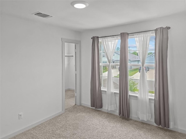 carpeted empty room featuring baseboards