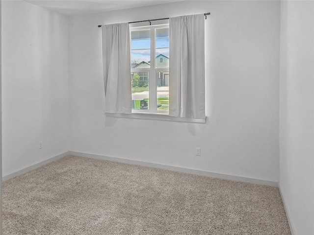 unfurnished room featuring carpet flooring and baseboards