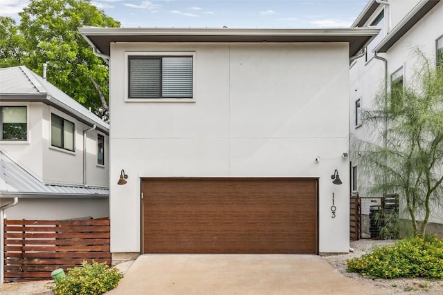 1103 12th St E, Austin, TX 78702 - contemporary home featuring an attached garage, stucco siding, and driveway