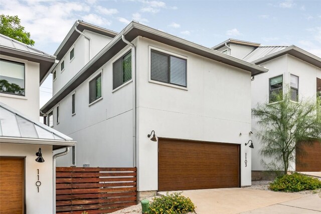 1103 12th St E, Austin, TX 78702 - view of front of house featuring stucco siding, driveway, and a garage