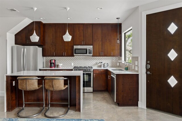 1103 12th St E, Austin, TX 78702 - kitchen with stainless steel appliances, a sink, light countertops, decorative backsplash, and recessed lighting