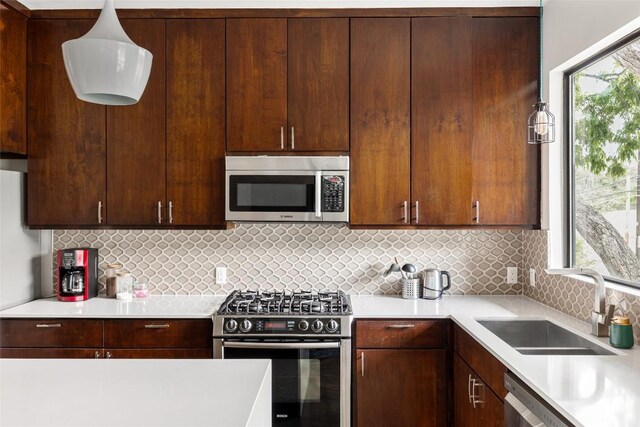 1103 12th St E, Austin, TX 78702 - kitchen with appliances with stainless steel finishes, a sink, light countertops, tasteful backsplash, and dark brown cabinetry