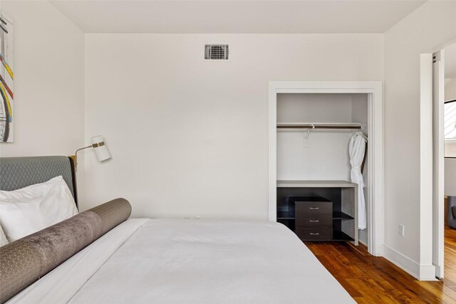 1103 12th St E, Austin, TX 78702 - bedroom featuring dark wood-style floors, a closet, and baseboards