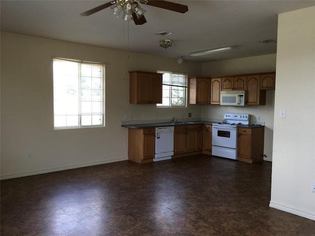 251 Zimmerman Ave A-B-C-D, Unit A-B-C-D, Bastrop, TX 78602 - kitchen with white appliances, a sink, ceiling fan, baseboards, and dark countertops