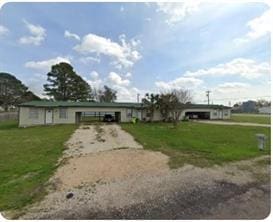 251 Zimmerman Ave A-B-C-D, Unit A-B-C-D, Bastrop, TX 78602 - ranch-style house with dirt driveway, a front lawn, and a carport