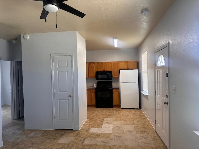 251 Zimmerman Ave A-B-C-D, Unit A-B-C-D, Bastrop, TX 78602 - kitchen with freestanding refrigerator, black microwave, stove, a ceiling fan, and baseboards