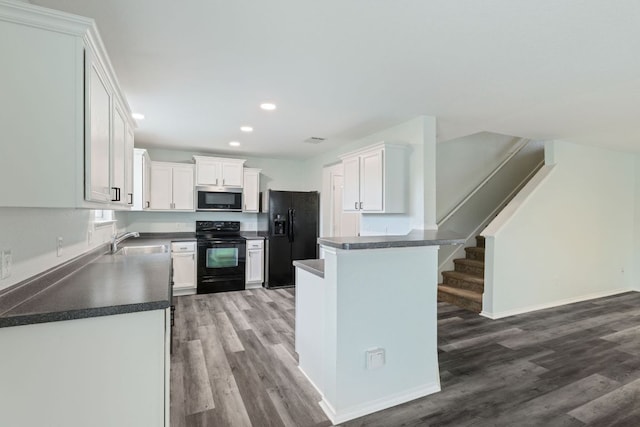 2306 Mccombs St, Georgetown, TX 78626 - kitchen with black appliances, wood finished floors, dark countertops, recessed lighting, and a sink