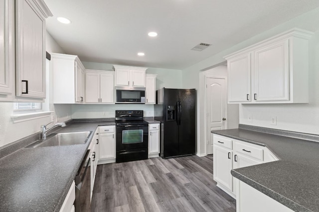 2306 Mccombs St, Georgetown, TX 78626 - kitchen with black appliances, a sink, white cabinetry, dark countertops, and recessed lighting