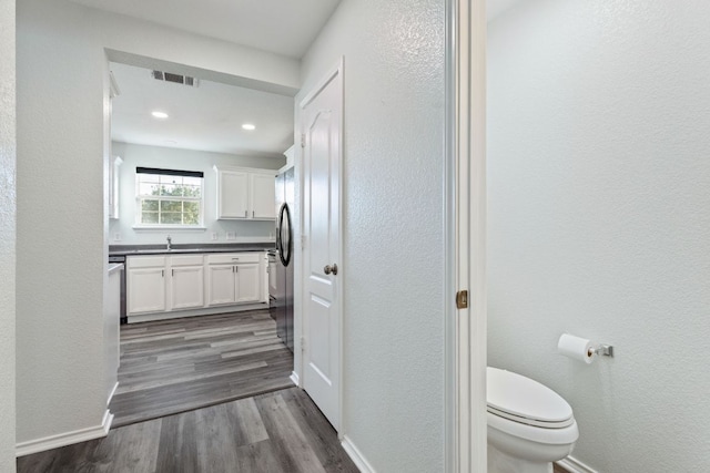 2306 Mccombs St, Georgetown, TX 78626 - bathroom with vanity, toilet, wood finished floors, a textured wall, and baseboards