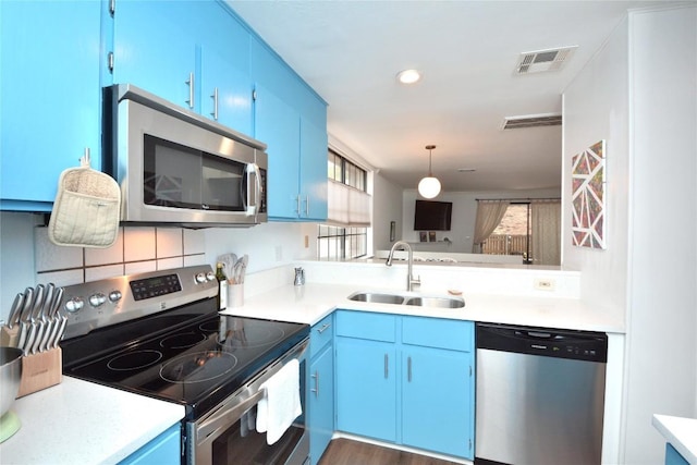 7122 Woodhollow Dr Unit 105, Austin, TX 78731 - kitchen featuring appliances with stainless steel finishes, blue cabinetry, light countertops, pendant lighting, and recessed lighting