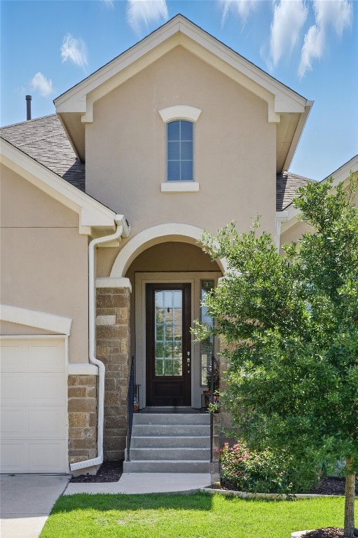 4121 Vinalopo Dr, Austin, TX 78738 - doorway to property with stucco siding, stone siding, roof with shingles, and an attached garage