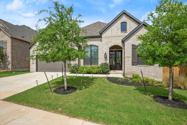 1244 Calendula Trl, Georgetown, TX 78628 - french country home featuring concrete driveway, a front yard, and french doors